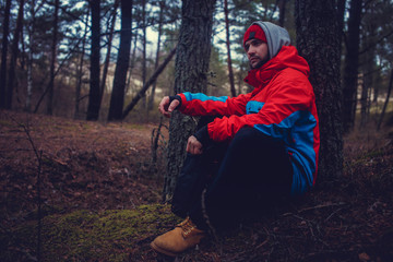 A man in red jacket in the forest.