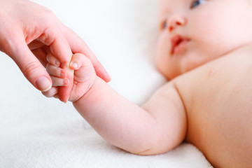 Fototapeta na wymiar concept of parental love. baby hand holding finger of mother