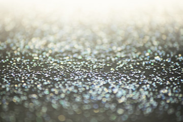 Unfocused abstract glitter holiday bokeh. silver golden lights. celebration card background.