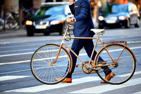 Fototapeta Man in perfect suit and old bike, typical Stockholm Scene