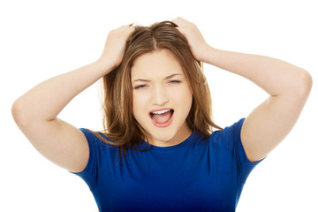 Frustrated young woman screaming.