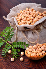 Chickpeas in a sack on a wooden background.