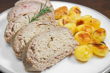 Meat loaf with roasted potatoes on dish
