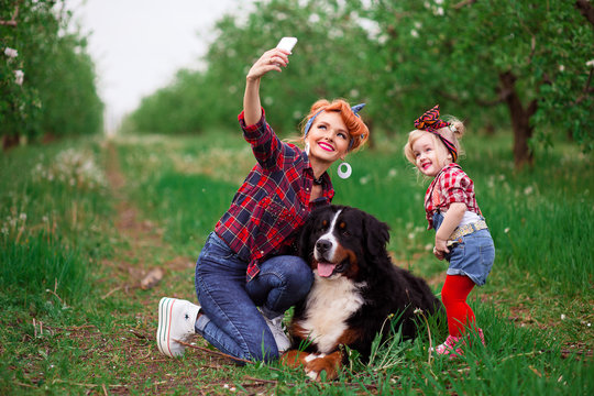 baby girl woman with dog bern in spring garden selfy