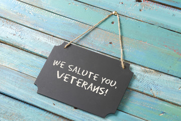 veterans day chalk sign on blue wood background with flag