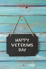 veterans day chalk sign on blue wood background with flag