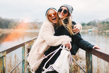 Outdoor lifestyle portrait of two best friends, smiling and having fun together, enjoy each other company posing and making selfie pictures to each other and share happiness
 - obrazy, fototapety, plakaty