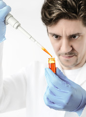 Keen scientist pipettes orange sample