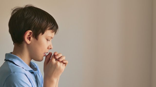 bot teen  praying on black background