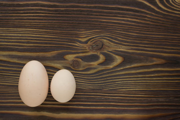 Two different eggs on the wooden background