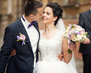 Beautiful bride and groom embracing and kissing on their wedding