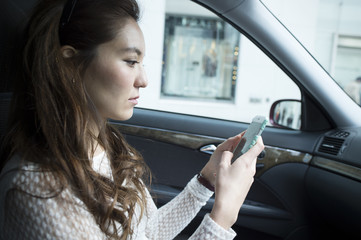 Young women have a portable game in the front passenger seat of the car