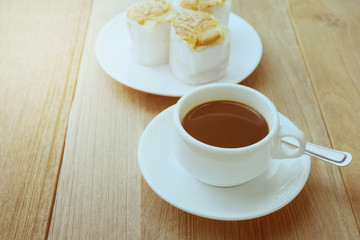 Cup of coffee on wooden table. Photo in old color image style