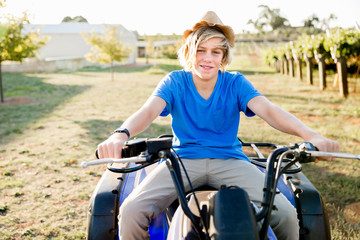 Boy riding farm truck in vineyard