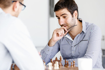 Portrait of two young man playing chess 