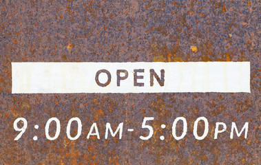 Metal open sign board in front of shop