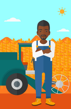 Man standing with combine on background.