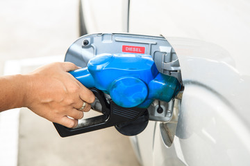 Refill fuel to a car at gas station.