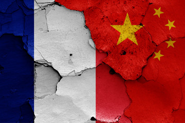 flags of France and China painted on cracked wall
