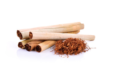 Tobacco pile and cigarette on white background