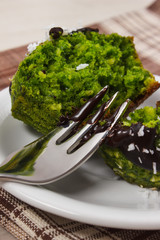 Fresh muffins with spinach, desiccated coconut and chocolate glaze, delicious healthy dessert