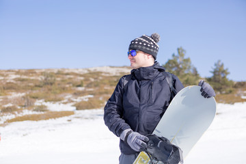 Fototapeta na wymiar Man holding snowboard in snow