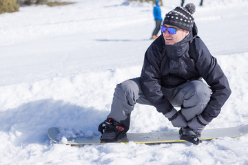 Fototapeta na wymiar Man putting on snowboard