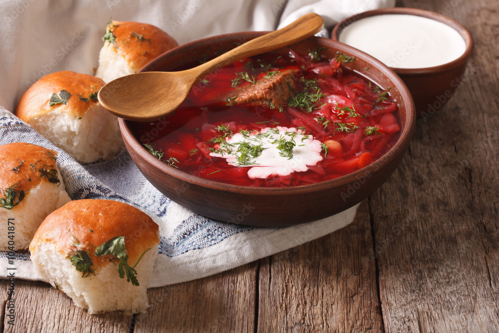 Poster ukrainian borscht red soup with garlic buns on the table. horizontal