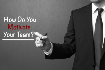 Business man writing: How Do You Motivate Your Team?