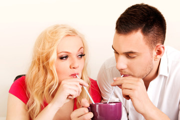 Cute couple drinking from one cup
