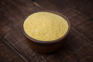 corn groats on wooden rustic table. Selective focus