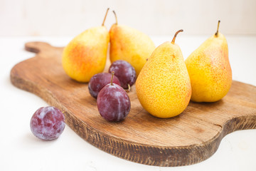 pears and plums lie on a board, selective focus