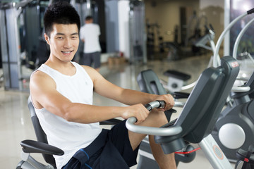 Fototapeta na wymiar young handsome man working out in modern gym