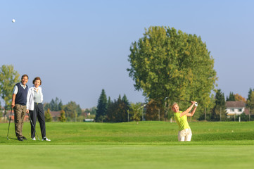 Junge Frau beim Spiel aus dem Sandbunker