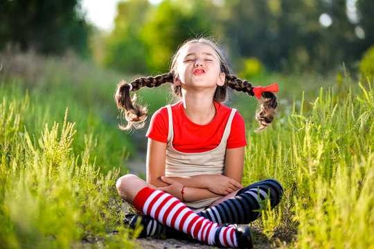 girl with pigtails imagines the summer on the nature