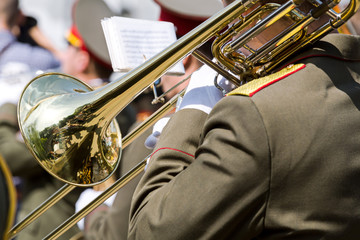 Fototapeta na wymiar military musician playing gold trombone on parade