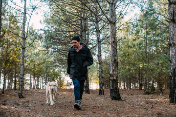 man with labrador dog walking in the wood