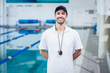 Handsome trainer standing with hands on the back