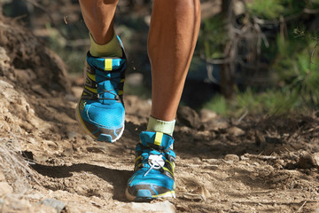 Trail running man on mountain path exercising