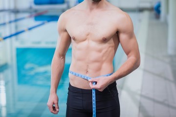 Obraz premium Fit man measuring his waist