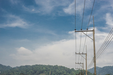 electricity post beside mountain view with few mist and gently c