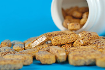 Pills spill out from bottle on a blue