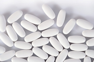 Top view of white pills on a white