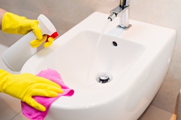 cleaning bidet in wc with pink cloth.