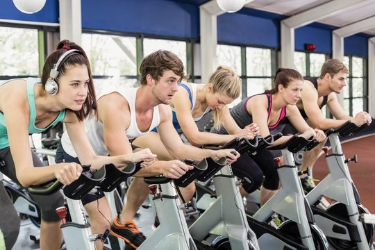Fit group of people using exercise bike together