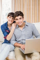 Obraz na płótnie Canvas Portrait of young couple using a laptop