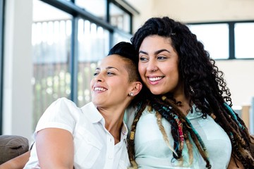 Smiling lesbian couple relaxing on sofa