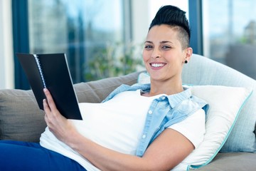 portrait of pregnant woman holding notepad
