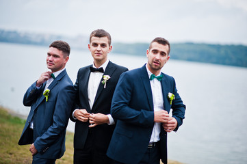 Three friends, groom with groomsman having fun