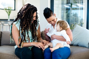 Lesbian couple playing with their baby